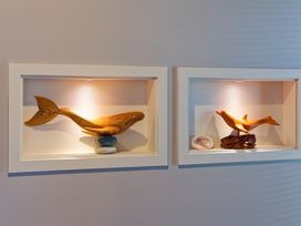 Wooden whale and dolphin carvings displayed in a living room at Kaikoura