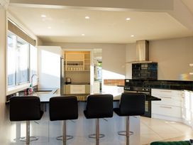 A kitchen with bar stools and sink at Kaikoura in Kaikoura