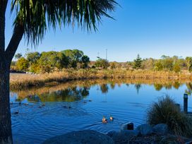 A serene pond with ducks swimming and surrounded by trees at Mountain View - Kaikoura Holiday Home, Kaikoura