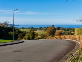 A road with a view of the ocean and trees at Mountain View - Kaikoura Holiday Home Kaikoura