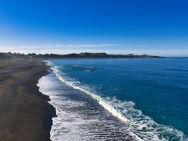 A beach with waves and a clear sky at Mountain View - Kaikoura Holiday Home Kaikoura