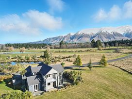 An outdoor view of a house with mountains in the background at The Alpine Edge - Windwhistle Holiday Home in Canterbury