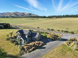 A house surrounded by grass and trees at The Alpine Edge - Windwhistle Holiday Home in Canterbury
