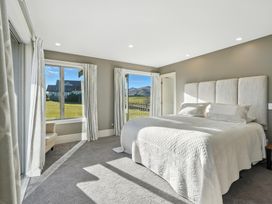 A bedroom with a bed and windows at The Alpine Edge - Windwhistle Holiday Home, Canterbury