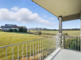 A view from a porch showing a house and mountains at The Alpine Edge - Windwhistle Holiday Home, Canterbury