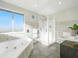 A bathroom with a bathtub, shower, and sink at The Alpine Edge - Windwhistle Holiday Home, Canterbury