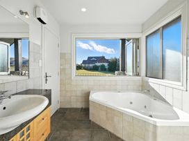 A bathroom with a bathtub and sink at The Alpine Edge - Windwhistle Holiday Home Canterbury