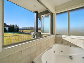 A bathroom with a bathtub and a view of the countryside at The Alpine Edge - Windwhistle Holiday Home in Canterbury
