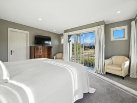 A bedroom with a bed and television at The Alpine Edge - Windwhistle Holiday Home Canterbury