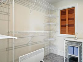 A laundry room with wire shelving and a window at The Alpine Edge - Windwhistle Holiday Home in Canterbury
