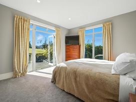 A bedroom with a bed and television at The Alpine Edge - Windwhistle Holiday Home in Canterbury