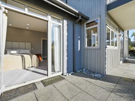 A bedroom with bed and door opening to outside at The Alpine Edge - Windwhistle Holiday Home, Canterbury