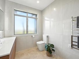 A bathroom with a sink, toilet, window and towel rack at The Alpine Edge - Windwhistle Holiday Home, Canterbury