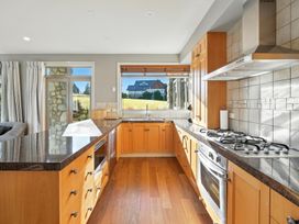 A kitchen with cabinets and appliances at The Alpine Edge - Windwhistle Holiday Home in Canterbury