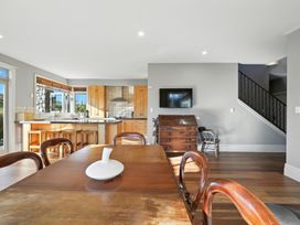 A dining room with a kitchen in the background at The Alpine Edge - Windwhistle Holiday Home, Canterbury
