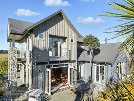 An exterior view of a house with a balcony and garden at The Alpine Edge - Windwhistle Holiday Home, Canterbury