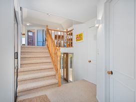 A staircase with a handrail and doors at Beachfront Landing - Pauanui Holiday Home, Pauanui