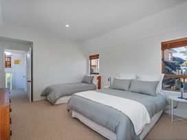 A bedroom with two beds and a window at Beachfront Landing - Pauanui Holiday Home Pauanui
