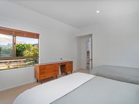 A bedroom with a bed and a desk at Beachfront Landing - Pauanui Holiday Home, Pauanui