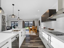 A kitchen with an island and dining area at Sunrise Hideaway - Cromwell