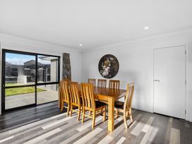 A dining room with a wooden table and chairs at Sunrise Hideaway - Cromwell