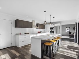 A kitchen with an island and bar stools at Sunrise Hideaway - Cromwell