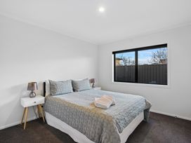A bedroom with a bed and bedside tables at Sunrise Hideaway - Cromwell Holiday Home, Cromwell