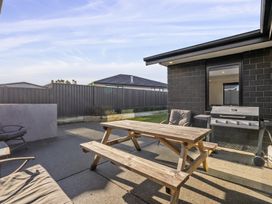 An outdoor area with a table and barbecue grill at Sunrise Hideaway - Cromwell Holiday Home, Cromwell