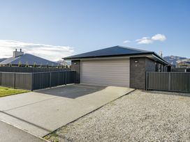 A house with a garage and fence at Sunrise Hideaway - Cromwell Holiday Home, Cromwell
