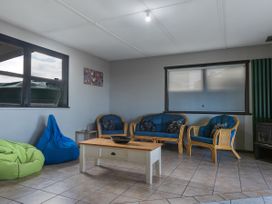 A living room with blue sofa and coffee table at Natives Nest - Karikari Peninsula Escape Kaitaia
