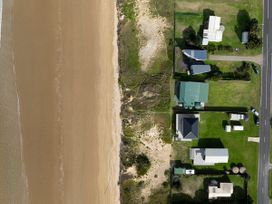 An aerial view of a beach and residential area at Natives Nest - Karikari Peninsula Escape, Kaitaia