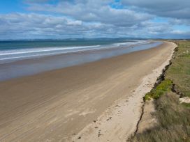A beach with sand and ocean waves at Natives Nest - Karikari Peninsula Escape Kaitaia
