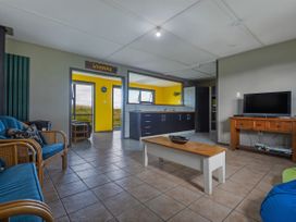 A living room with a coffee table and television at Natives Nest - Karikari Peninsula Escape in Kaitaia