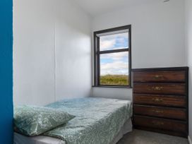 A bedroom with a bed and a dresser at Natives Nest - Karikari Peninsula Escape Kaitaia