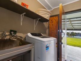 A laundry room with a washing machine and sink at Natives Nest - Karikari Peninsula Escape Kaitaia