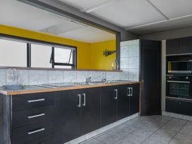 A kitchen with cabinets and appliances at Natives Nest - Karikari Peninsula Escape Kaitaia