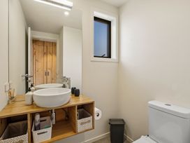 A bathroom with a wash basin and toilet at Eight on Jackson - Luggate Holiday Home