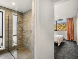 A bathroom with a glass shower and a view of a bedroom at Eight on Jackson - Luggate Holiday Home