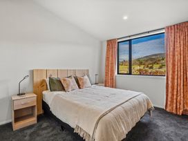 A bedroom with a bed and bedside table at Eight on Jackson - Luggate Holiday Home