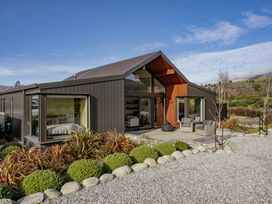 An outdoor area with a house and seating at Eight on Jackson - Luggate Holiday Home