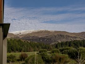 A view of mountains with snow and trees at Eight on Jackson - Luggate Holiday Home