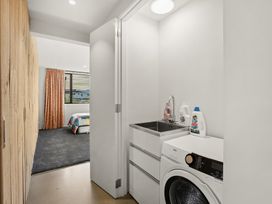 A laundry room with a washing machine and sink at Eight on Jackson - Luggate Holiday Home