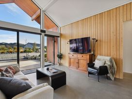 A living room with a sofa and a television at Eight on Jackson - Luggate Holiday Home
