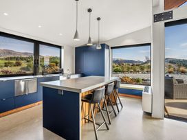 A kitchen with a countertop and stools at Eight on Jackson - Luggate Holiday Home
