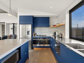 A kitchen with a stove and refrigerator at Eight on Jackson - Luggate Holiday Home