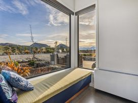 A snug room with a bench and large windows at Eight on Jackson - Luggate Holiday Home