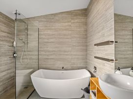 A bathroom with a shower, bathtub, and sink at Eight on Jackson - Luggate Holiday Home