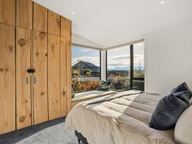 A bedroom with a bed and wardrobe at Eight on Jackson - Luggate Holiday Home