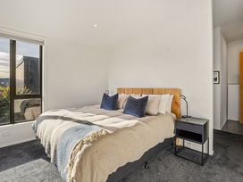 A bedroom with a bed and bedside table at Eight on Jackson - Luggate Holiday Home