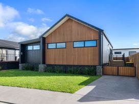 A house with wood and stone features at Waihi Beach Holiday Home in Waihi Beach
